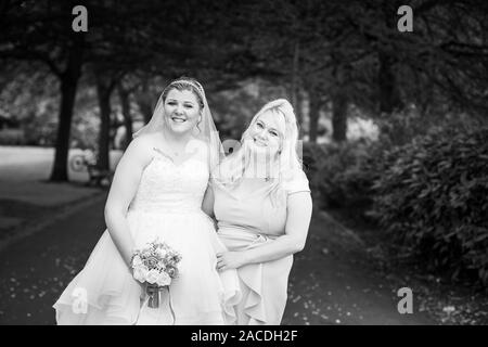 Braut und Brautjungfern haben Hochzeitsfotos in Floral Hall, Tunstall Park, Stoke on Trent, Hochzeitsfotos, Feiern, traditionelle englische Hochzeit Stockfoto