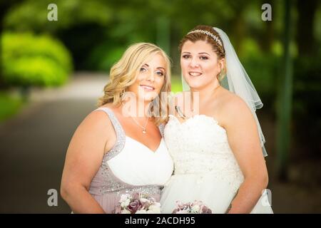 Braut und Brautjungfern haben Hochzeitsfotos in Floral Hall, Tunstall Park, Stoke on Trent, Hochzeitsfotos, Feiern, traditionelle englische Hochzeit Stockfoto