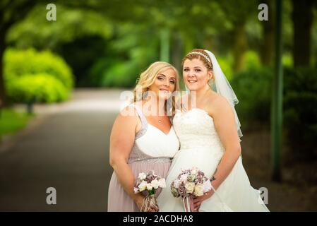 Braut und Brautjungfern haben Hochzeitsfotos in Floral Hall, Tunstall Park, Stoke on Trent, Hochzeitsfotos, Feiern, traditionelle englische Hochzeit Stockfoto