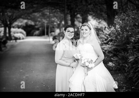 Braut und Brautjungfern haben Hochzeitsfotos in Floral Hall, Tunstall Park, Stoke on Trent, Hochzeitsfotos, Feiern, traditionelle englische Hochzeit Stockfoto