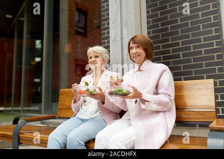 Ältere Frauen essen Essen zum Mitnehmen auf die Stadt. Stockfoto
