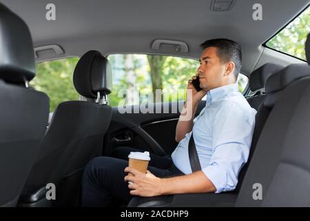 Geschäftsmann mit Kaffee Aufruf auf dem Telefon im Auto. Stockfoto