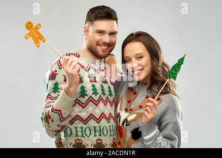 Paar mit Weihnachtsfeier Requisiten in hässlichen Pullover Stockfoto