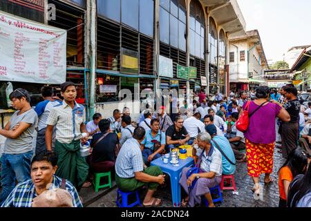 Menschen außerhalb eines Cafe Trinken von Tee und Kaffee in der Bogyoke Aung San Markt, Yangon, Myanmar sitzen. Stockfoto