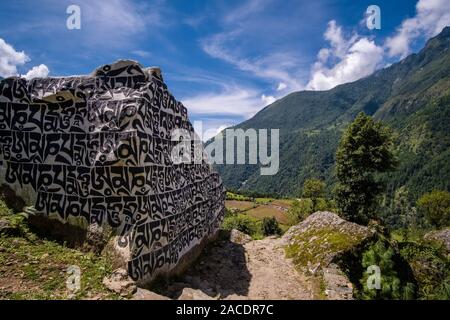 Big Mani Steine mit den eingravierten tibetische Mantra Om Mani Padme Hum, am Eingang des Dorfes Stockfoto