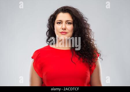 Die Frau im roten Kleid über grauer Hintergrund Stockfoto