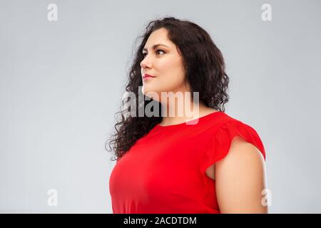 Die Frau im roten Kleid über grauer Hintergrund Stockfoto