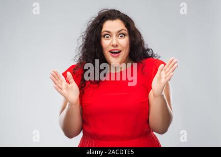 Glücklich überrascht Frau im roten Kleid Stockfoto