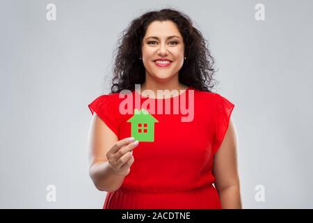 Glückliche Frau im roten Kleid Holding green house Symbol Stockfoto