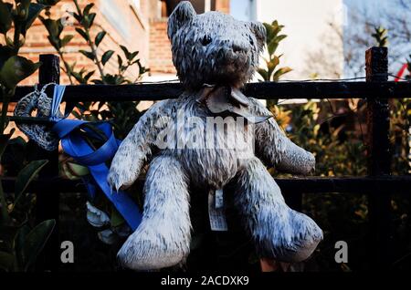 London, Großbritannien. 2. Dez, 2019. Ein Teddybär Memorial sitzt zu fechten in der Nähe der Überreste von Grenfell Turm fest, im Juni 2017 durch ein Feuer zerstört, in Folien in North Kensington, London. 70 - zwei Menschen starben in der Flamme, deren Schweregrad viele Bewohner danach die Schuld auf die Auswirkungen von Jahren der konservativen Regierung die Vernachlässigung der Region und dem sozialen Wohnungsbau. Seit Jahrzehnten durch Konservative Partei Abgeordnete vertreten, North Kensington fällt in den parlamentarischen Wahlkreis von Kensington, die derzeit die meisten in ganz England rn, gewonnen aus den Tories Stockfoto