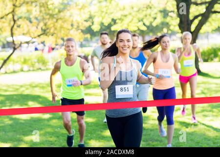 Glückliche junge Läuferin am Ende erfolgreichen Rennen Stockfoto