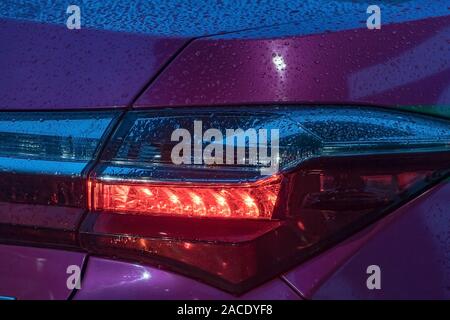 Nahaufnahme der Beleuchtung auto Heckleuchte. Rücklicht mit Haube mit Tropfen bedeckt. Stockfoto