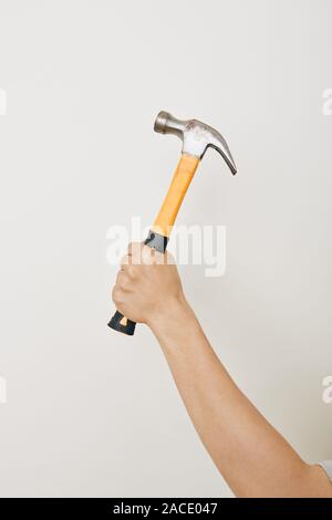 Hand der Handwerker holding Hammer mit Schwarz und Gelb auf weißem Hintergrund Griff Stockfoto