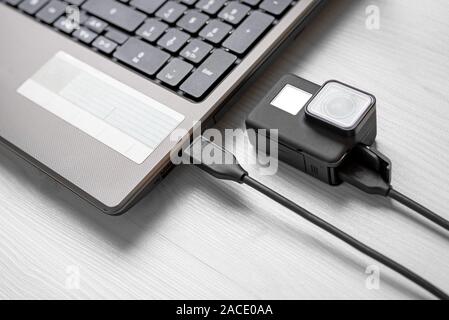 Action Kamera Laptop angeschlossen über USB-Kabel. Close-up. Stockfoto