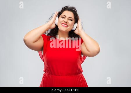 Glückliche Frau in Kopfhörer Musik hören Stockfoto