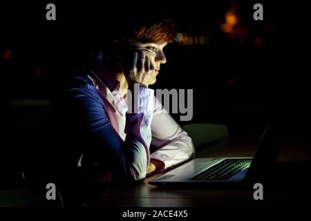 Junge schöne Frau auf eine Universität Vortrag, der an einem Notebook arbeitet bei Nacht Stockfoto