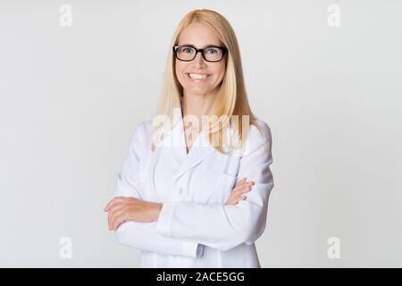 Freundliche Frau Doktor in weiße Uniform, lächelnd in die Kamera Stockfoto