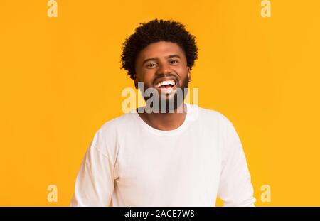 Freudige african american Kerl über orange Hintergrund Stockfoto