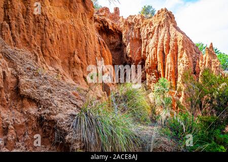 Hohe rote Lehm Felsen und Klippen von Regen- und Oberflächenwasser fließt Wasser gewaschen. Ton Steinbruch, Minen Landschaft Szene in Cilento und Vallo di Diano Nation Stockfoto