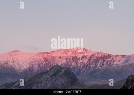 Letzte Sonne des Tages auf schneebedeckten Snowdon Mountain. Landschaft, Tele Stockfoto