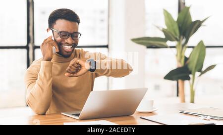 Gerne schwarze Kerl schaut auf eine Wand am Telefon sprechen Stockfoto
