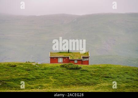 Hütte Holz- Berghütten in Mountain Pass Norwegen. Norwegische Landschaft mit typischen skandinavischen gras dach Häuser. Bergdorf mit kleinen Häusern Stockfoto