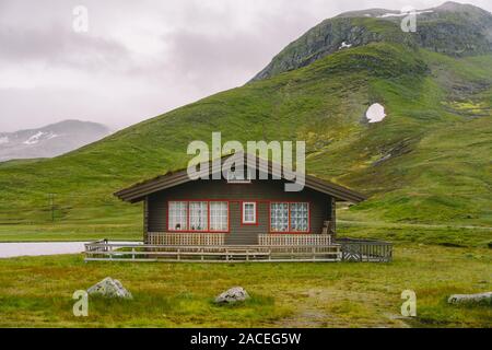 Hütte Holz- Berghütten in Mountain Pass Norwegen. Norwegische Landschaft mit typischen skandinavischen gras dach Häuser. Bergdorf mit kleinen Häusern Stockfoto