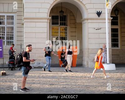 Fotograf fliegen eine Hand bedienten drone in Rynok Square, dem Zentrum von Lwiw, Ukraine Stockfoto