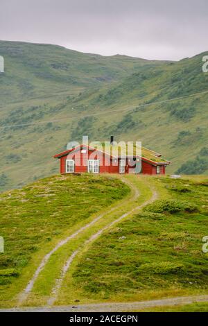 Hütte Holz- Berghütten in Mountain Pass Norwegen. Norwegische Landschaft mit typischen skandinavischen gras dach Häuser. Bergdorf mit kleinen Häusern Stockfoto
