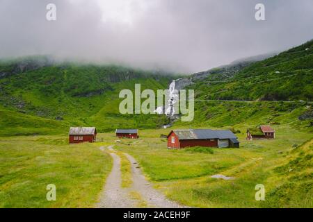 Hütte Holz- Berghütten in Mountain Pass Norwegen. Norwegische Landschaft mit typischen skandinavischen gras dach Häuser. Bergdorf mit kleinen Häusern Stockfoto