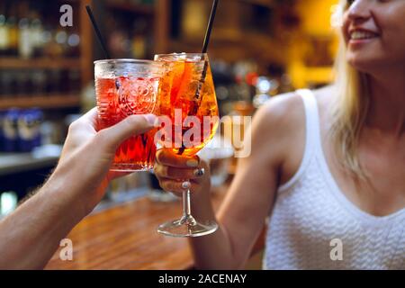 Frau und Mann Anheben einer Brille von Cocktails in der Bar Hintergrund Stockfoto