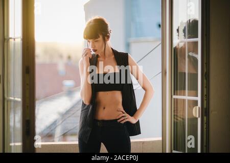 Ein Mädchen standind auf dem Balkon Ihrer Wohnung. Stockfoto