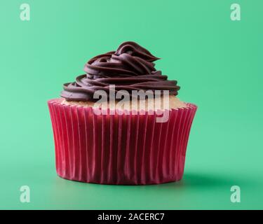 Leckere hausgemachte sweet Vanilla Cupcake mit Schokoladenglasur, grüner Hintergrund Stockfoto