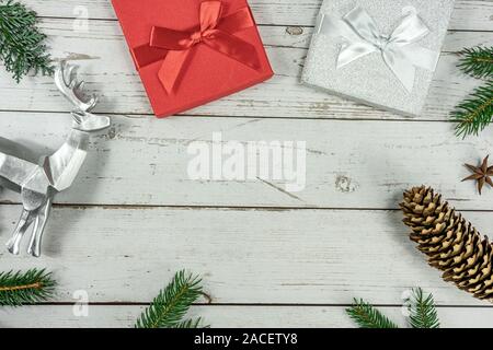 Weihnachten Rahmen Hintergrund flach auf weißem Holz mit Geschenkbox und andere natürliche Dekoration legen. Stockfoto