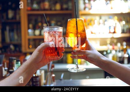 Frau und Mann Anheben einer Brille von Cocktails in der Bar Hintergrund Stockfoto