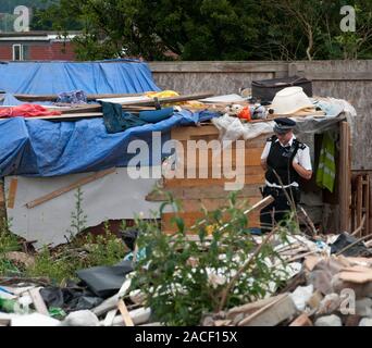 Polizei- und Beamte der Agentur, die Räumung von rumänischen Einwanderer aus einem Elendsviertel auf einem verlassenen Ort an der ehemaligen Hendon United Football Ground in North West London gebaut. Stockfoto