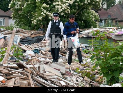 Polizei- und Beamte der Agentur, die Räumung von rumänischen Einwanderer aus einem Elendsviertel auf einem verlassenen Ort an der ehemaligen Hendon United Football Ground in North West London gebaut. Stockfoto