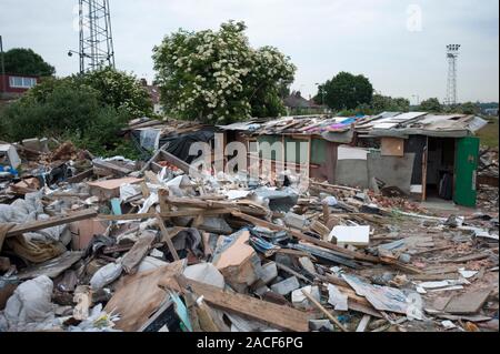 Polizei- und Beamte der Agentur, die Räumung von rumänischen Einwanderer aus einem Elendsviertel auf einem verlassenen Ort an der ehemaligen Hendon United Football Ground in North West London gebaut. Stockfoto