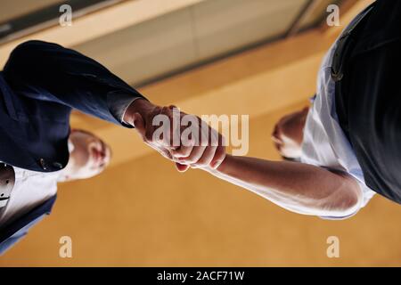 Zwei Geschäftspartnern Händeschütteln nach Versiegelung ist ein Deal, Ansicht von unten Stockfoto