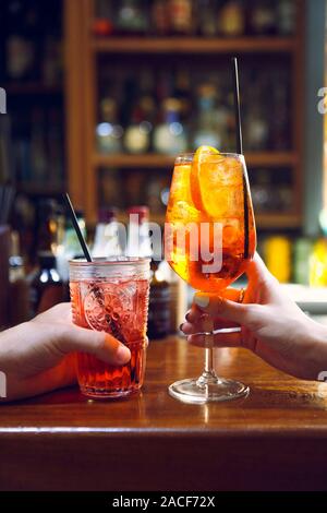 Frau und Mann Anheben einer Brille von Cocktails in der Bar Hintergrund Stockfoto