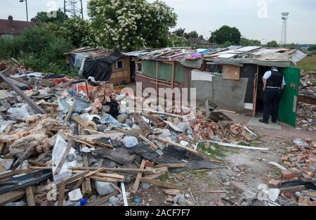 Polizei- und Beamte der Agentur, die Räumung von rumänischen Einwanderer aus einem Elendsviertel auf einem verlassenen Ort an der ehemaligen Hendon United Football Ground in North West London gebaut. Stockfoto