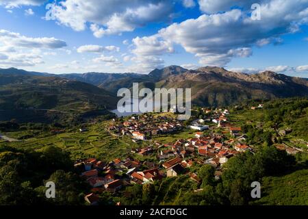 Antenne Panoramablick auf das historische Dorf Lindoso, die umliegenden Berge und den See, am Nationalpark Peneda Geres, in Portugal. Stockfoto