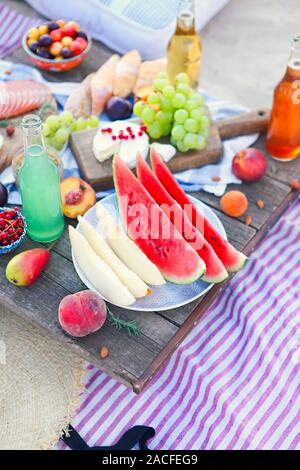 Picknick am Strand bei Sonnenuntergang im Stil von Boho. Essen und Trinken, Entspannen, urlaub Konzept Stockfoto