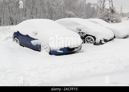 Autos auf den Parkplatz durch tief verschneite nach schweren Schneefällen. Schlechtes Wetter im Winter. Stockfoto