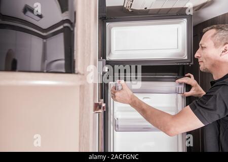 RV Recreational Vehicle Appliances Techniker Reparatur defekter Travel Trailer Kühlschrank. Stockfoto