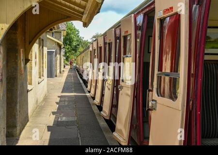 CRANMORE, ENGLAND - Juli 2019: Kutschen in einem Zug mit Türen auf der Plattform Cranmore Station auf der East Somerset Steam Railway öffnen. Stockfoto