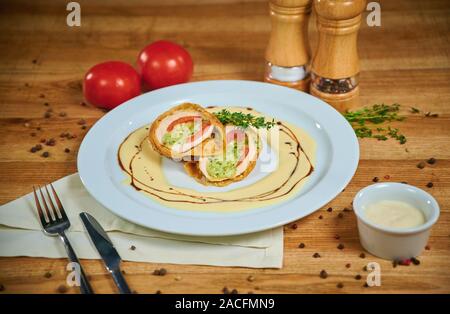 Leckeres Hähnchenbrustfilet überbacken mit Caprese. Anordnung mit Besteck Stockfoto