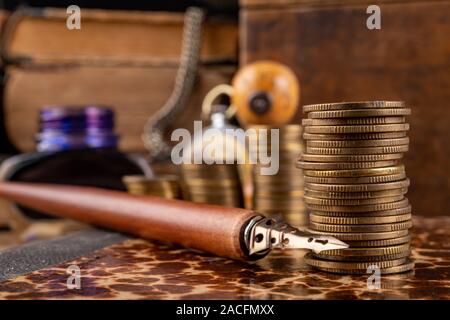 Münzen in Bars auf einem alten Buch angeordnet. Arbeitsplatz ein Buchhalter in einem alten Unternehmen. Der dunkle Hintergrund. Stockfoto