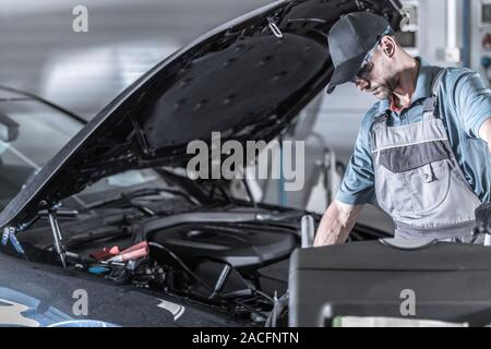 Auto Service Mechaniker Suchen unter der Motorhaube. Geplante Wartung. Stockfoto