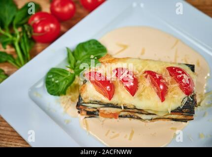 Schwarz, Italien Lasagne mit Lachs und Pilze auf weiße Platte im Restaurant. Stockfoto